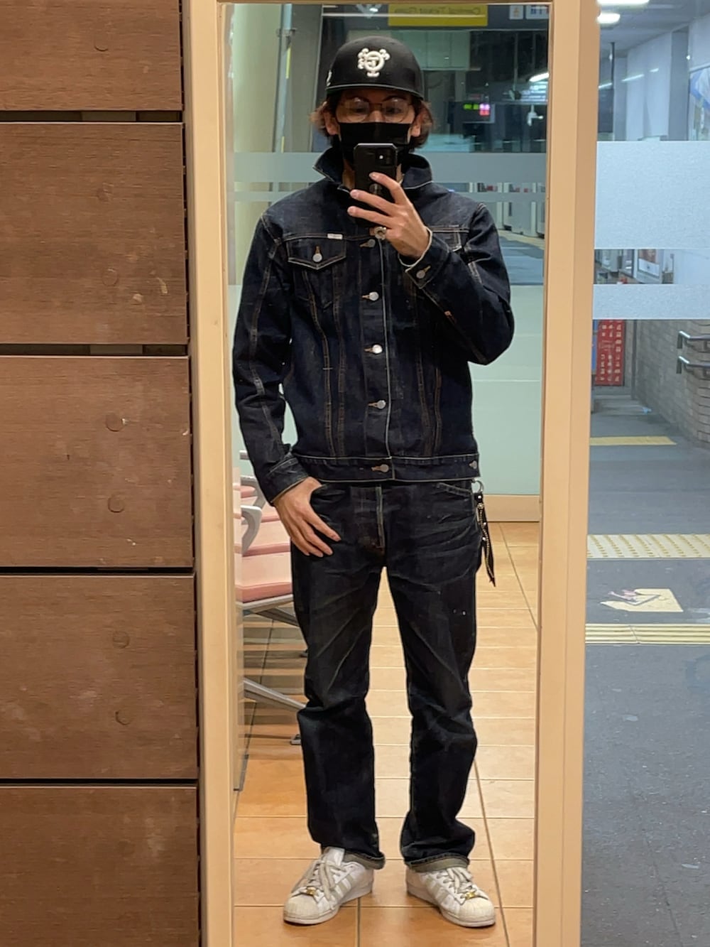 ホワイト系のスニーカー、ブルー系のデニムパンツ、ブルー系のデニムジャケットを着用したメンズの冬コーディネートの2枚目の写真