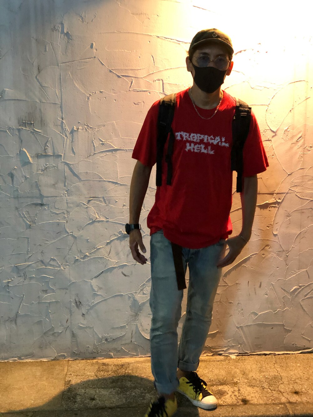 レッド系のTシャツ/カットソー、ブルー系のデニムパンツ、イエロー系のスニーカーを着用したメンズの秋コーディネートの3枚目の写真