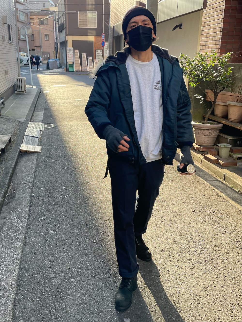 ブルー系のミリタリージャケット、ブルー系のチノパンツ、ブラック系のブーツを着用したメンズの冬コーディネートの2枚目の写真