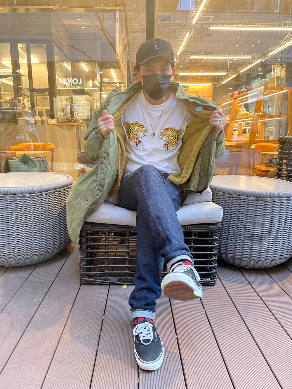 ホワイト系のTシャツ/カットソー、ブルー系のデニムパンツ、ブラック系のスニーカーを着用したメンズの冬コーディネートの2枚目の写真