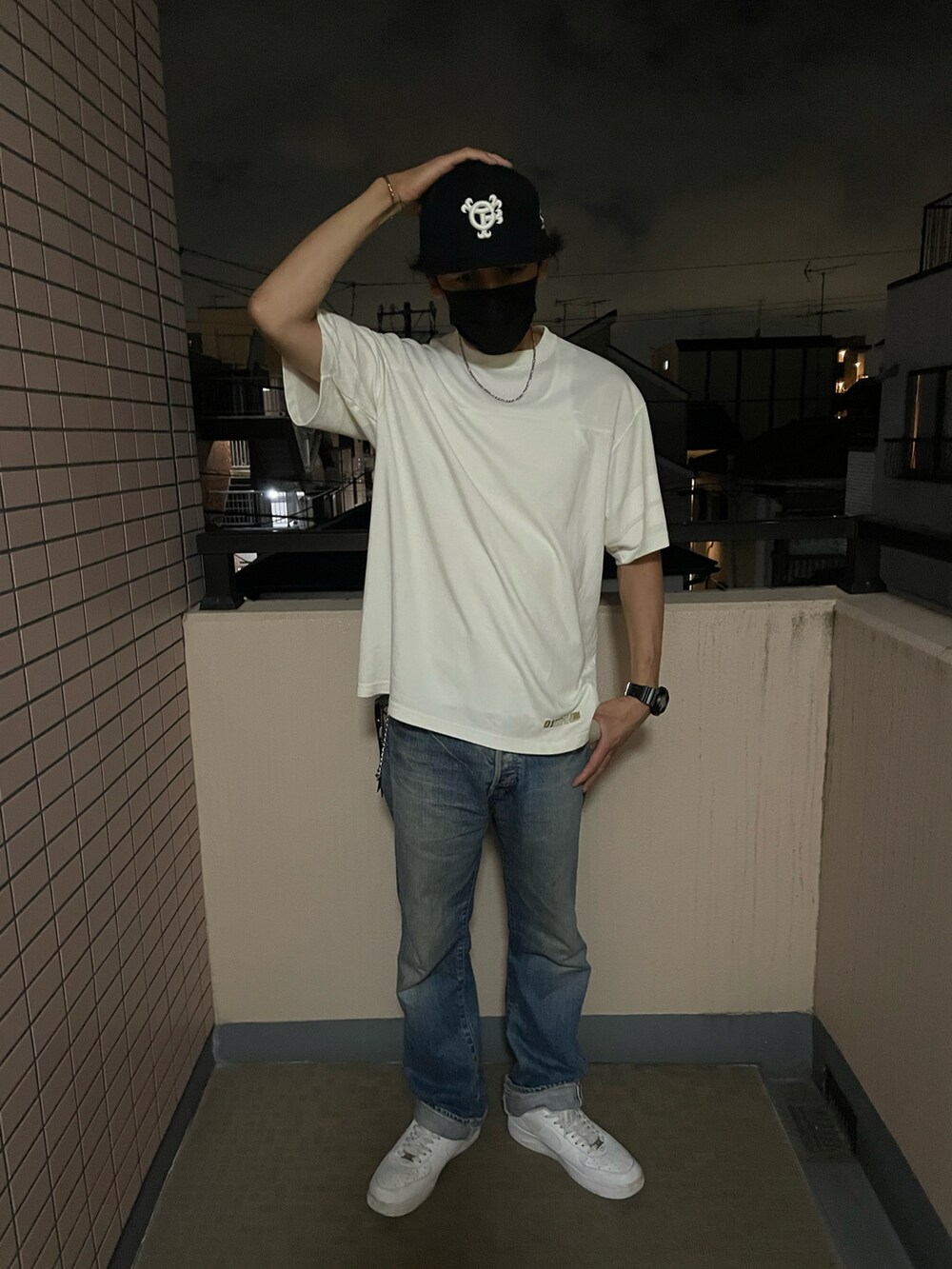 ホワイト系のTシャツ/カットソー、ブルー系のデニムパンツ、ホワイト系のスニーカーを着用したメンズの冬コーディネートの2枚目の写真