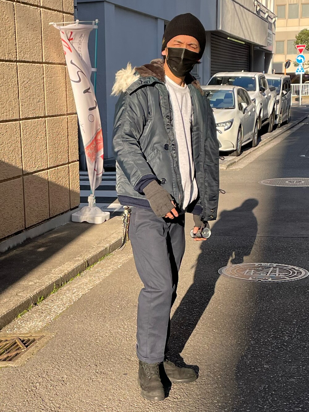 ブルー系のミリタリージャケット、ブルー系のチノパンツ、ブラック系のブーツを着用したメンズの冬コーディネートの4枚目の写真