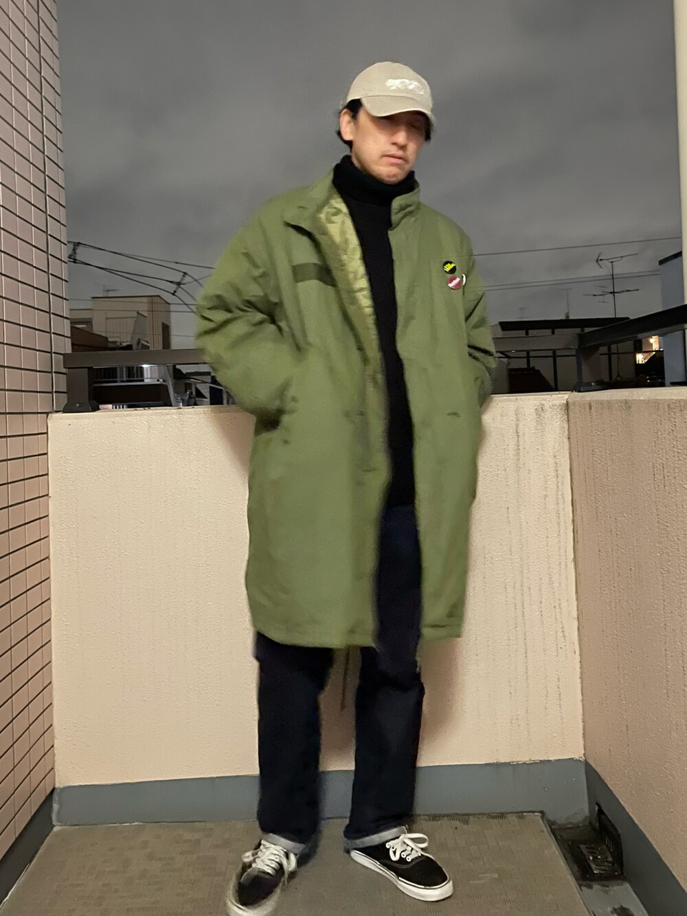 ブラック系のニット/セーター、ブルー系のデニムパンツ、ブラック系のスニーカーを着用したメンズの冬コーディネートの3枚目の写真