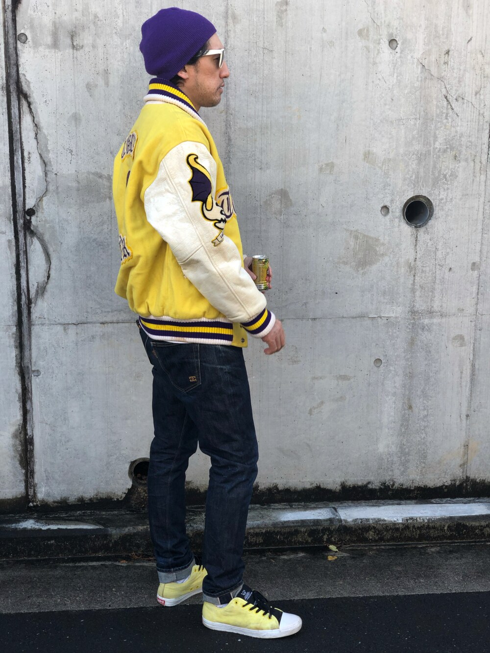 ホワイト系のTシャツ/カットソー、イエロー系のスタジャン、ブルー系のデニムパンツを着用したメンズの秋コーディネートの4枚目の写真