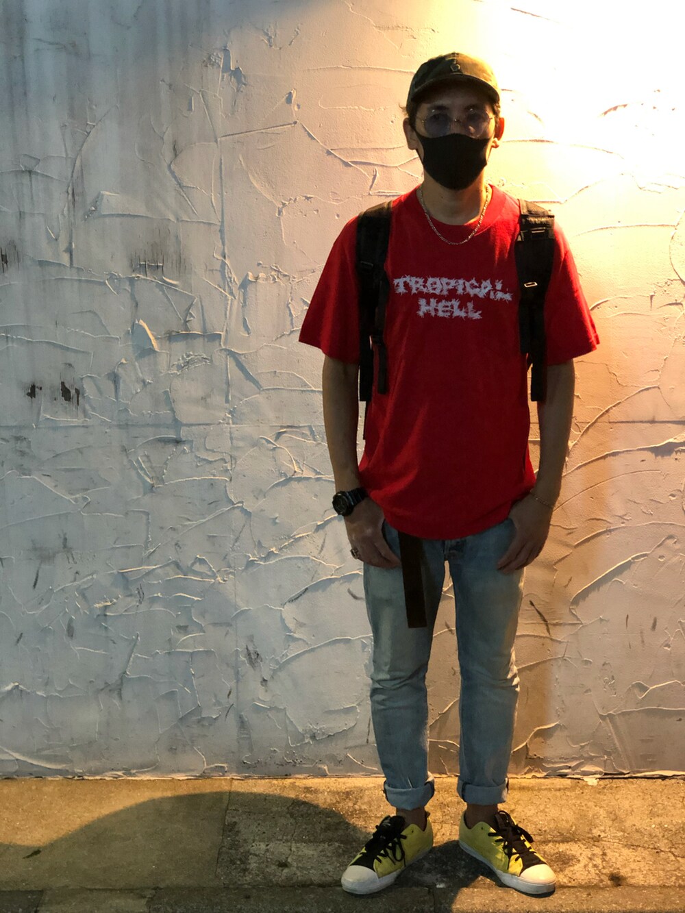 レッド系のTシャツ/カットソー、ブルー系のデニムパンツ、イエロー系のスニーカーを着用したメンズの秋コーディネートの2枚目の写真