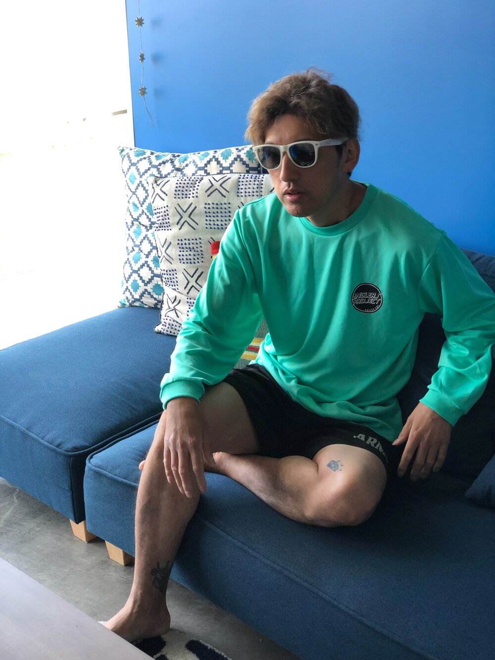 グリーン系のTシャツ/カットソー、ブラック系の水着を着用したメンズの秋コーディネートの2枚目の写真