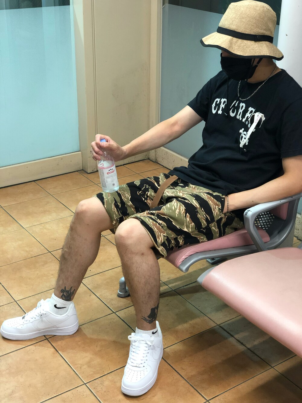 ブラック系のTシャツ/カットソー、グリーン系のカーゴパンツ、ホワイト系のスニーカーを着用したメンズの秋コーディネートの5枚目の写真