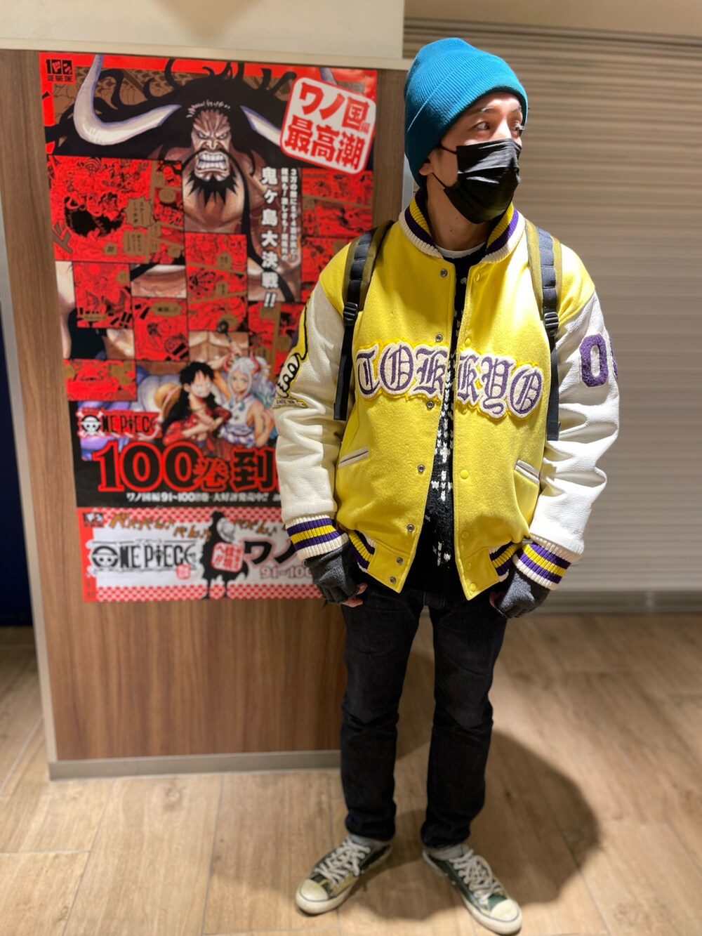 ブルー系のデニムパンツ、ブラック系のニット/セーター、イエロー系のスタジャンを着用したメンズの冬コーディネートの2枚目の写真