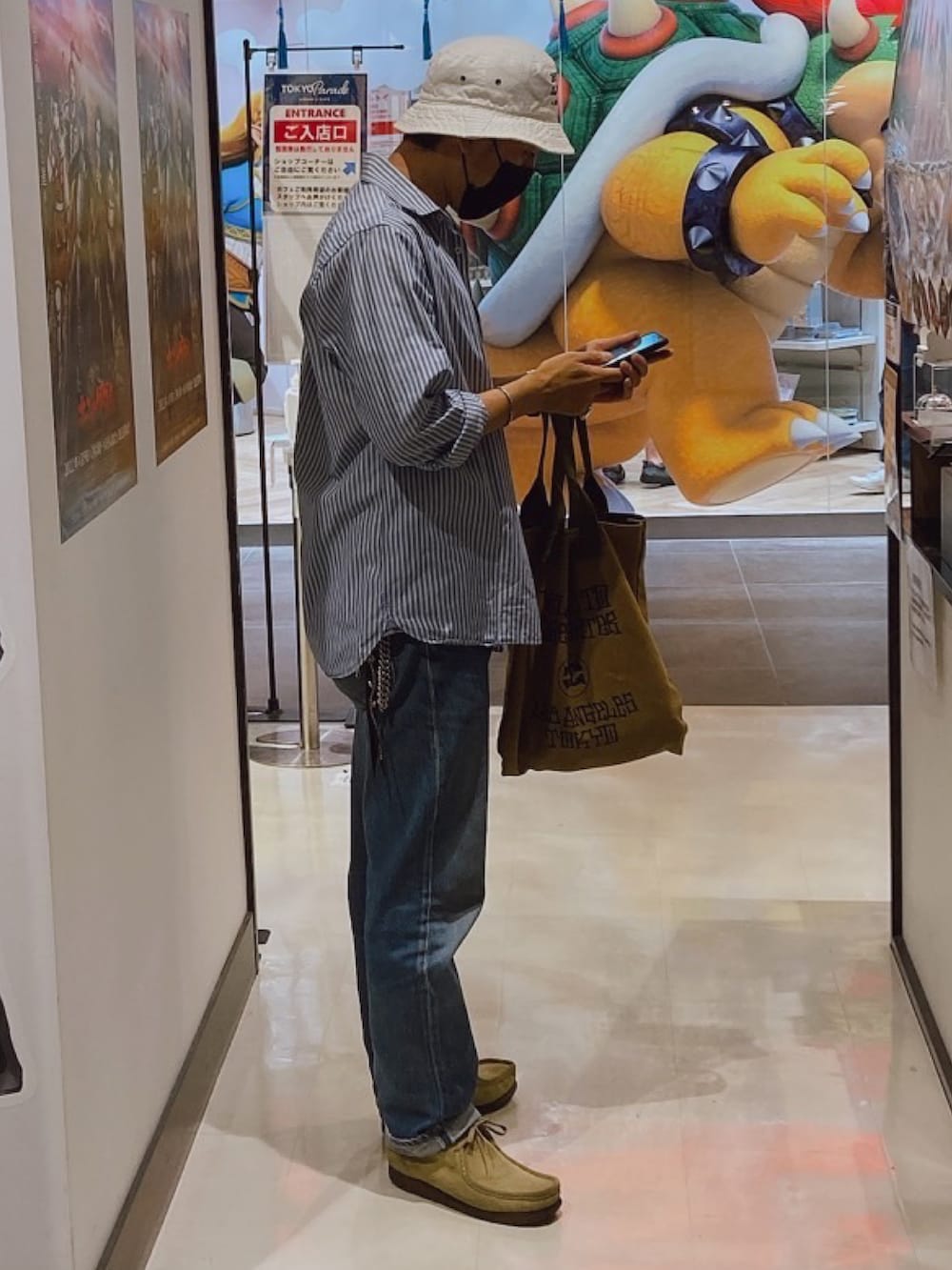 ホワイト系のTシャツ/カットソー、グリーン系のトートバッグ、ブルー系のシャツ/ブラウスを着用したメンズの冬コーディネートの2枚目の写真