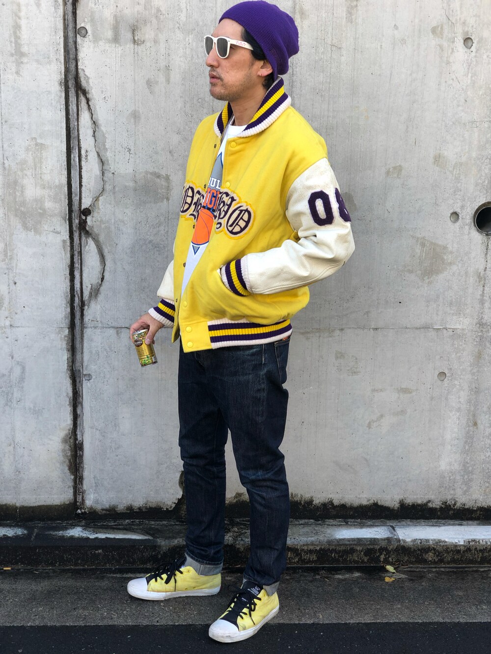 ホワイト系のTシャツ/カットソー、イエロー系のスタジャン、ブルー系のデニムパンツを着用したメンズの秋コーディネートの2枚目の写真