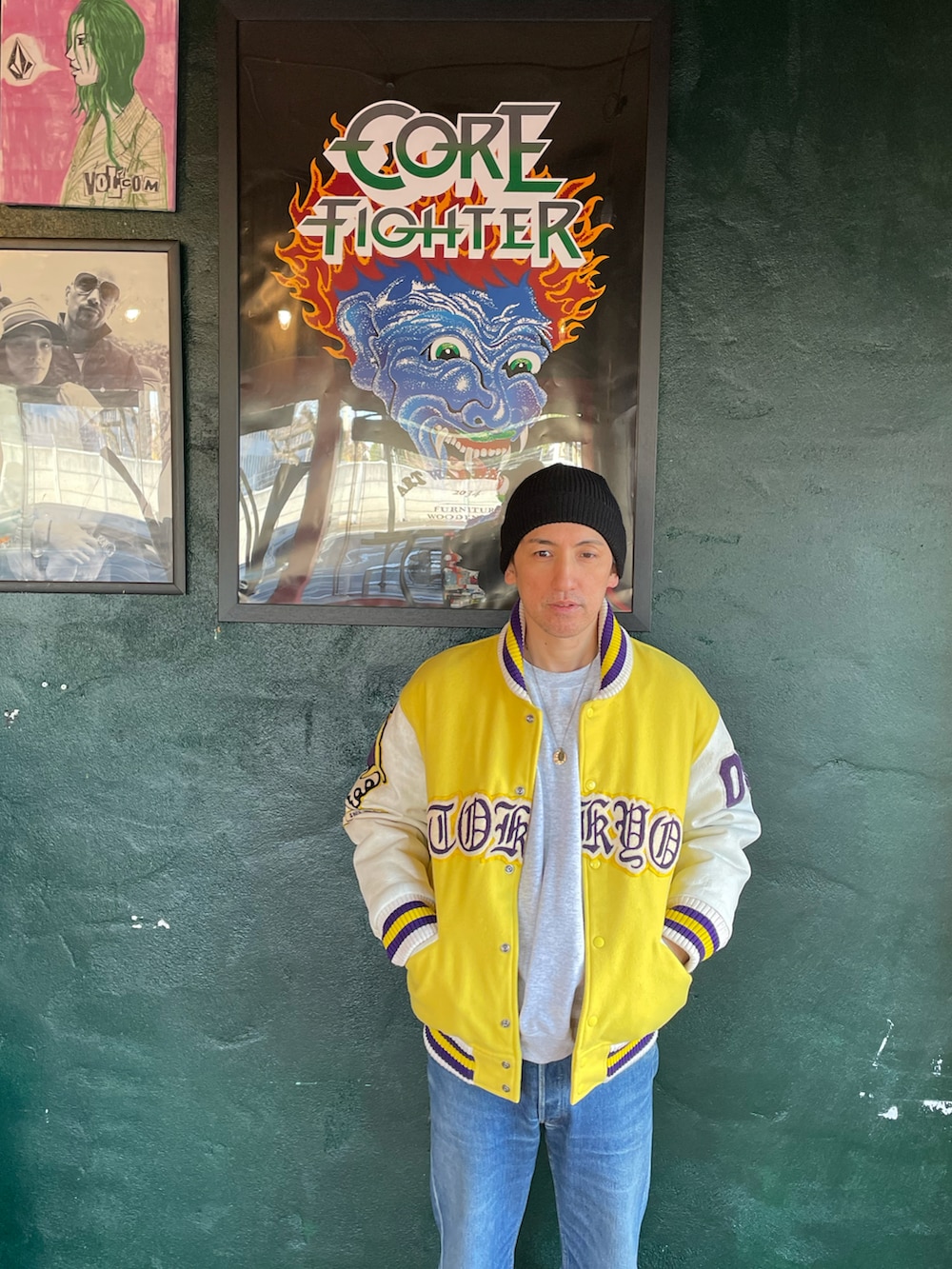 イエロー系のスタジャン、ブルー系のデニムパンツ、グリーン系のスニーカーを着用したメンズの冬コーディネートの2枚目の写真