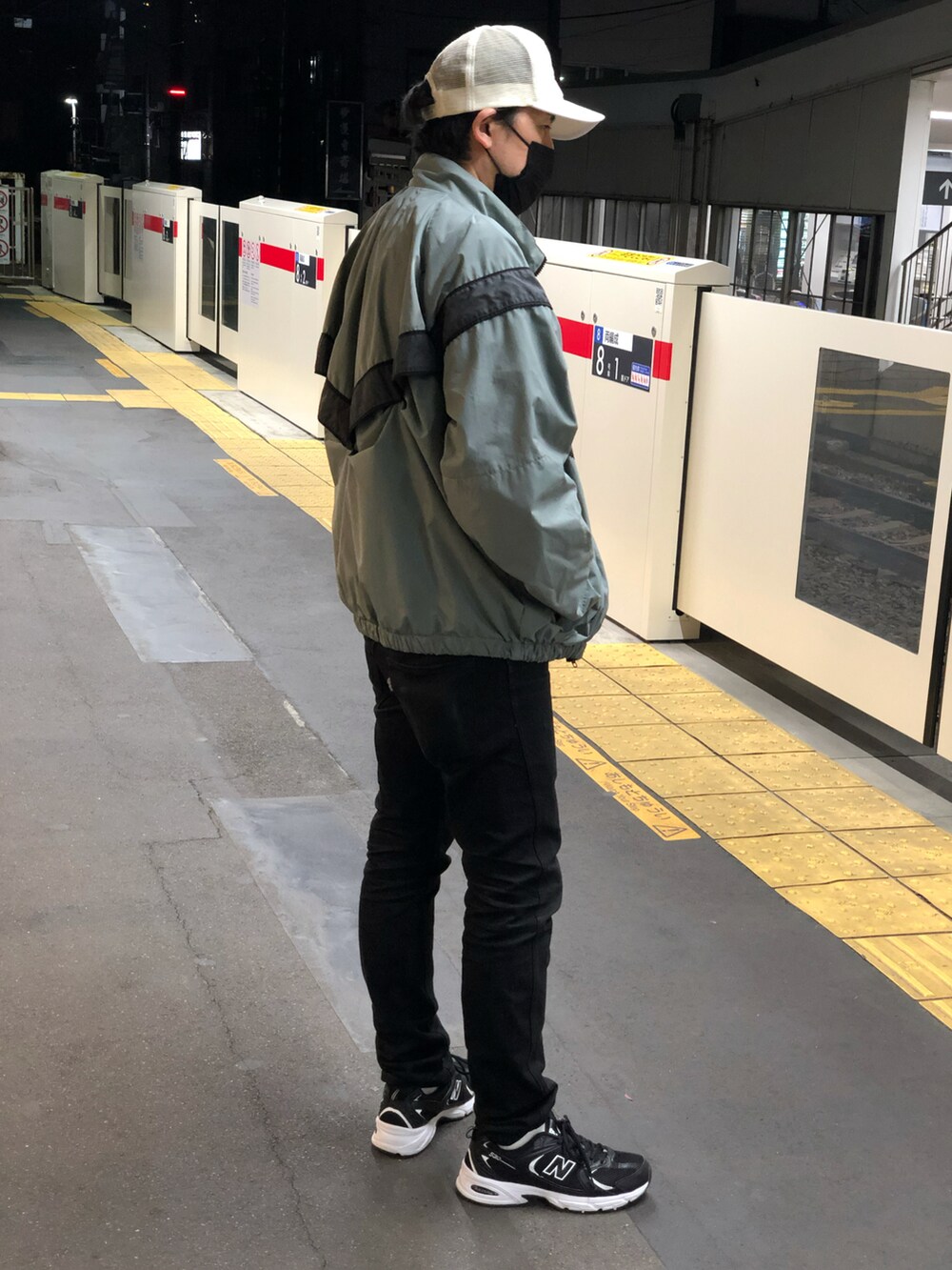 ブラック系のスニーカー、ブラック系のデニムパンツ、ホワイト系のTシャツ/カットソーを着用したメンズの秋コーディネートの2枚目の写真