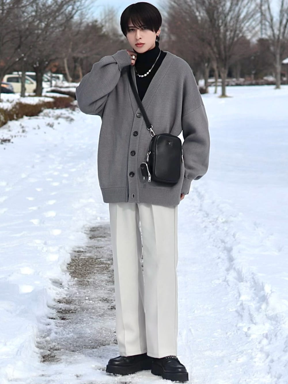 ブラック系のトレンチコート、グレー系のカーディガン/ボレロ、ブラック系のショルダーバッグを着用したメンズの冬コーディネートの2枚目の写真