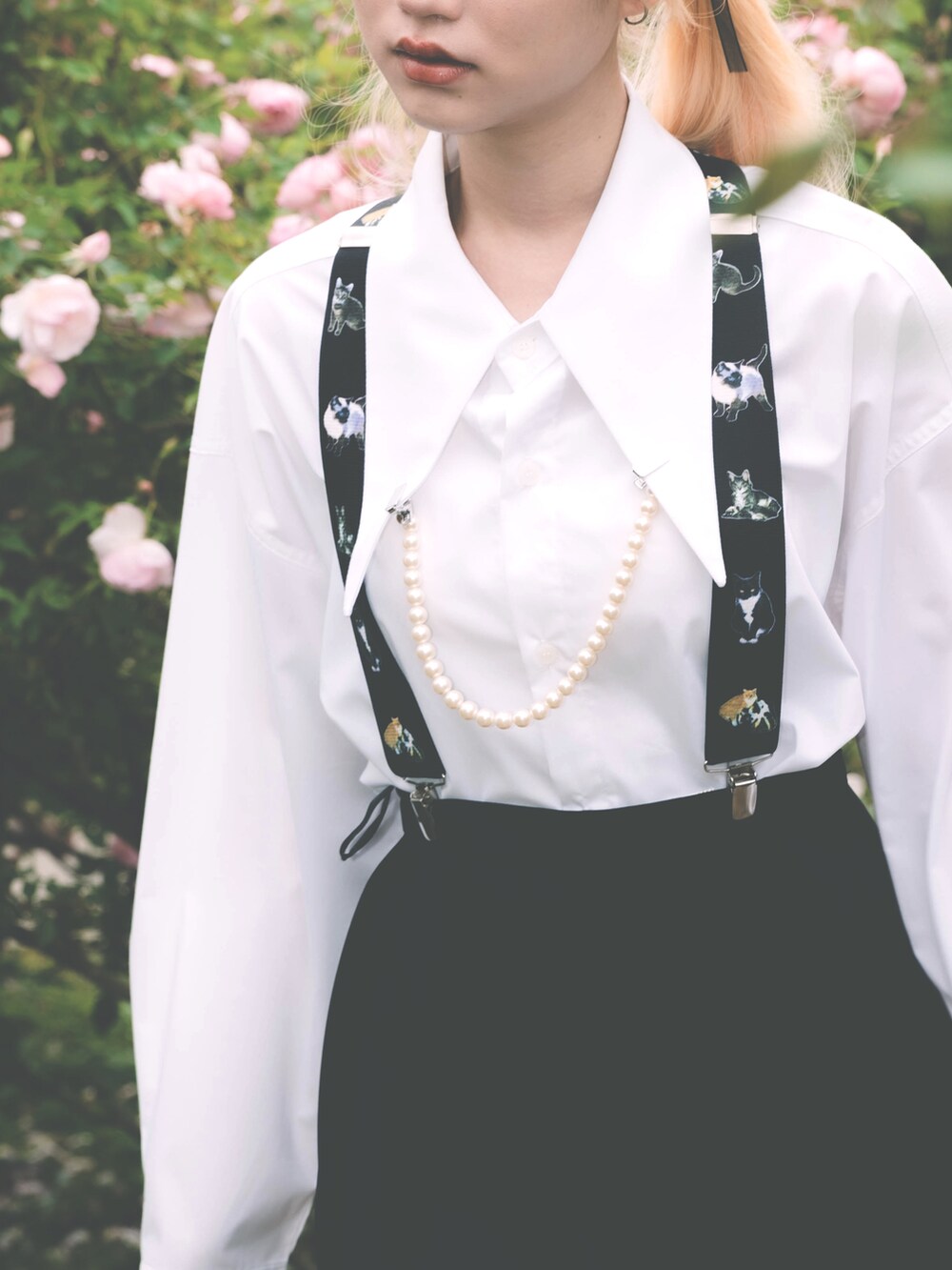 ホワイト系のシャツ/ブラウス、ブラック系のサスペンダー、ホワイト系のブローチ/コサージュを着用したレディースの夏コーディネートの2枚目の写真