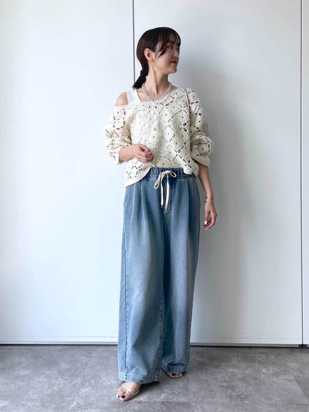 ホワイト系のニット/セーター、ブルー系のその他パンツ、シルバー系のネックレスを着用したレディースの秋コーディネートの2枚目の写真