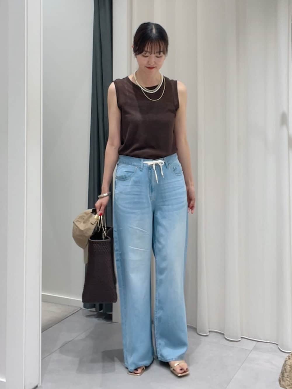 ブラウン系のTシャツ/カットソー、ブルー系のデニムパンツ、ゴールド系のブーツを着用したレディースの夏コーディネートの2枚目の写真