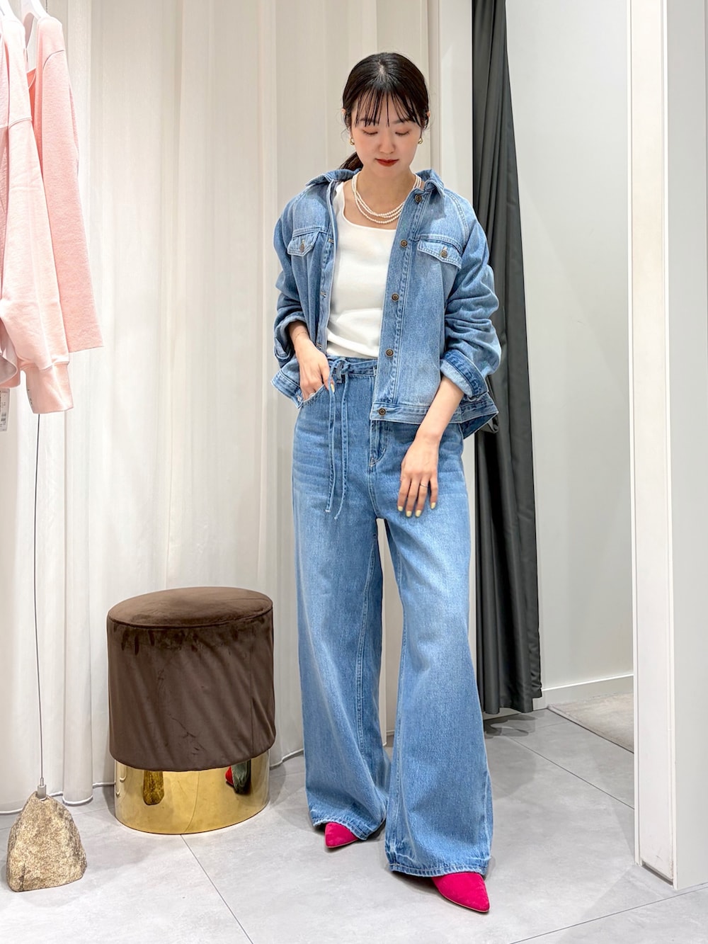 ブルー系のデニムパンツ、ブルー系のその他アウター、ホワイト系のタンクトップを着用したレディースの春コーディネートの2枚目の写真