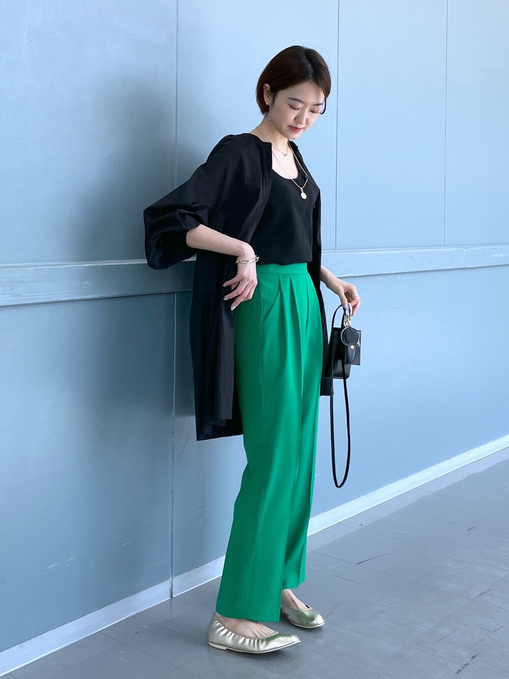 ブラック系のシャツ/ブラウス、グリーン系のその他パンツ、ブラック系のショルダーバッグを着用したレディースの春コーディネートの2枚目の写真