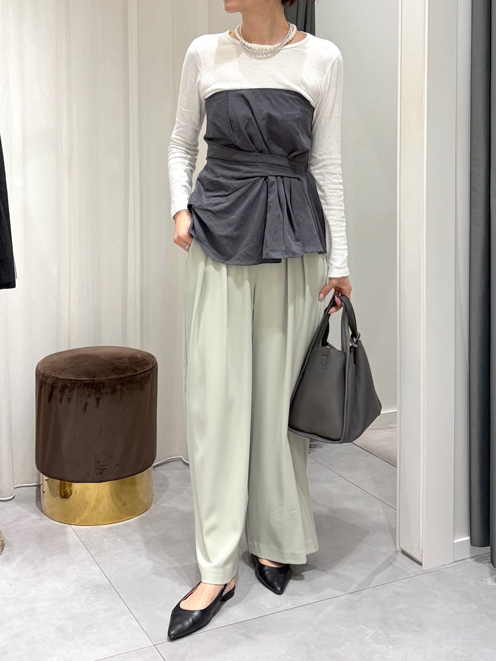 グレー系のシャツ/ブラウス、グリーン系のスラックス、グレー系のハンドバッグを着用したレディースの春コーディネートの3枚目の写真