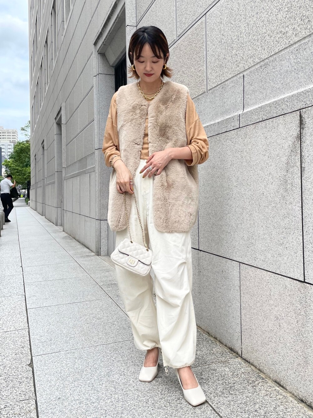 ベージュ系のベスト、イエロー系のTシャツ/カットソー、ホワイト系のその他パンツを着用したレディースの夏コーディネートの2枚目の写真