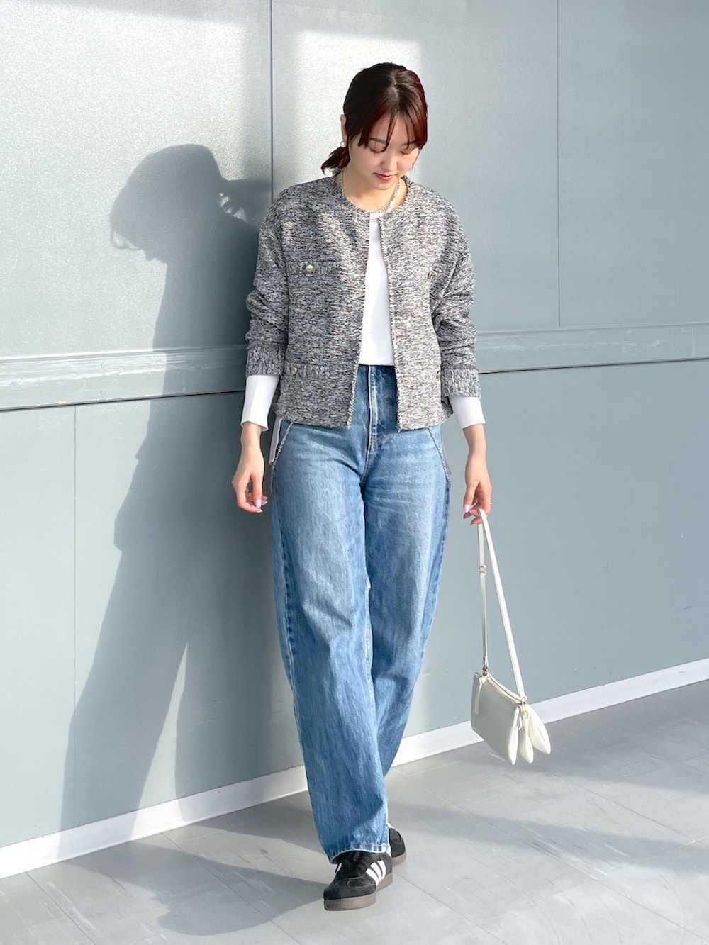 ブラック系のノーカラージャケット、ホワイト系のシャツ/ブラウス、ブルー系のデニムパンツを着用したレディースの冬コーディネートの2枚目の写真