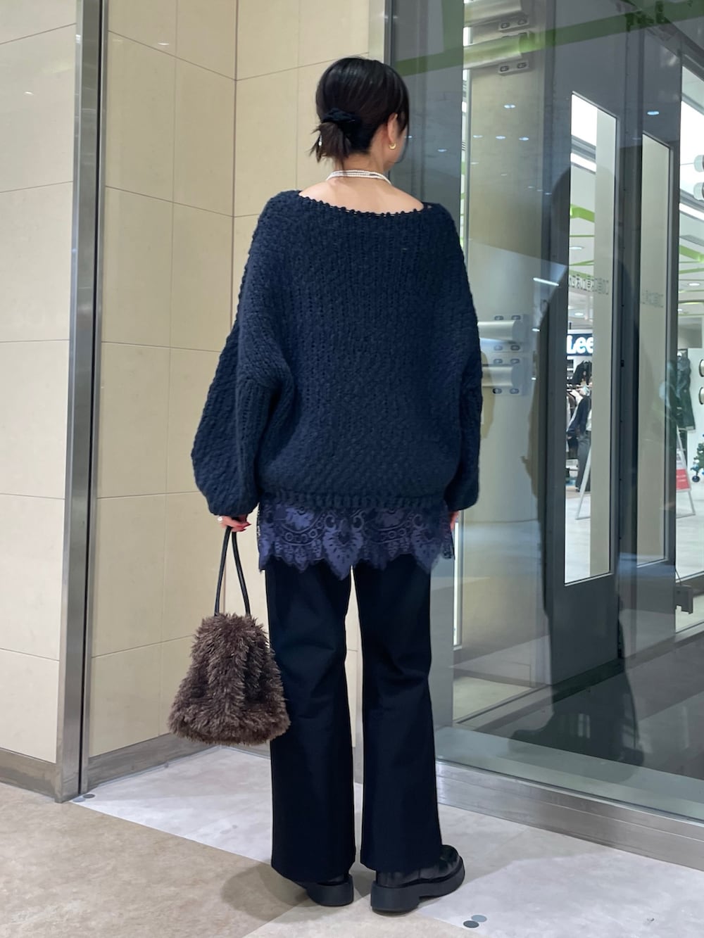 ブルー系のニット/セーター、ブルー系のシャツ/ブラウス、ブラウン系のショルダーバッグを着用したレディースの秋コーディネートの3枚目の写真