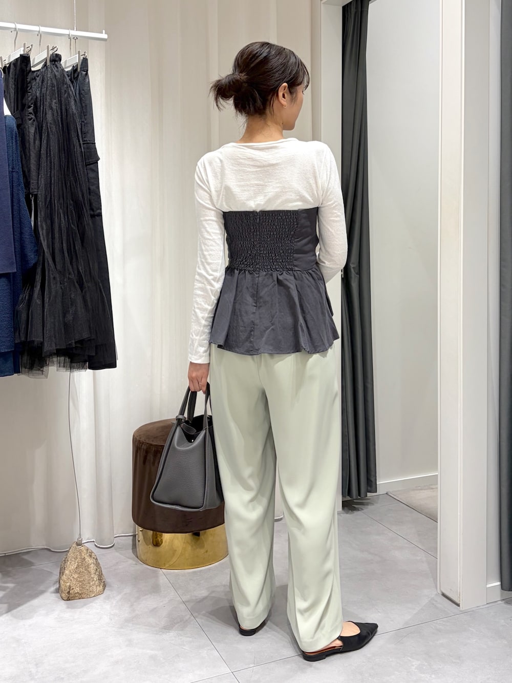 グレー系のシャツ/ブラウス、グリーン系のスラックス、グレー系のハンドバッグを着用したレディースの春コーディネートの2枚目の写真