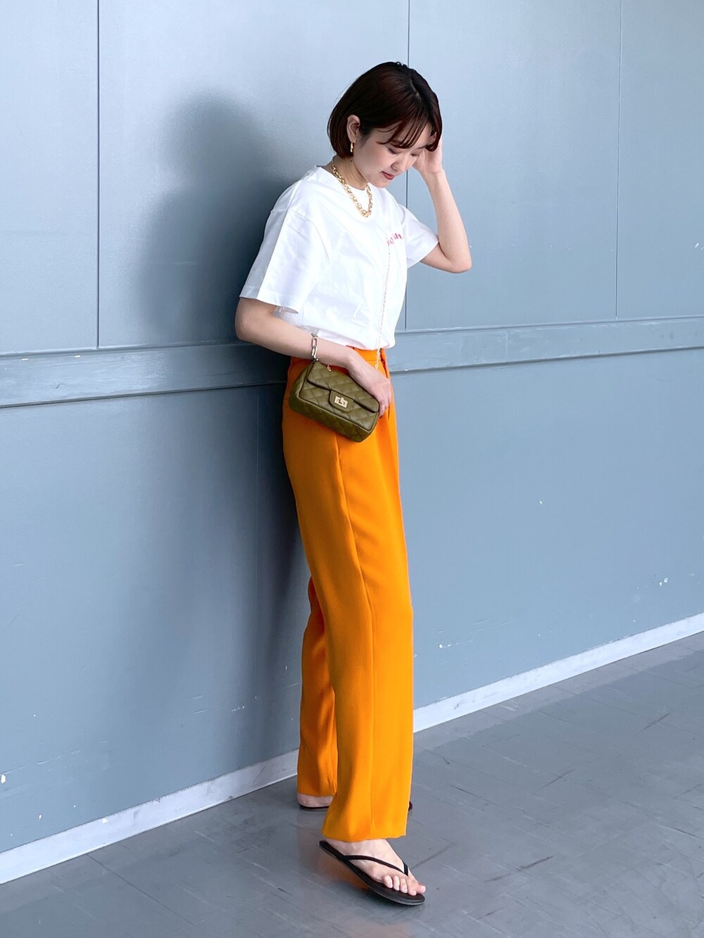 グリーン系のショルダーバッグ、オレンジ系のその他パンツ、ブラック系のその他シューズを着用したレディースの夏コーディネートの2枚目の写真
