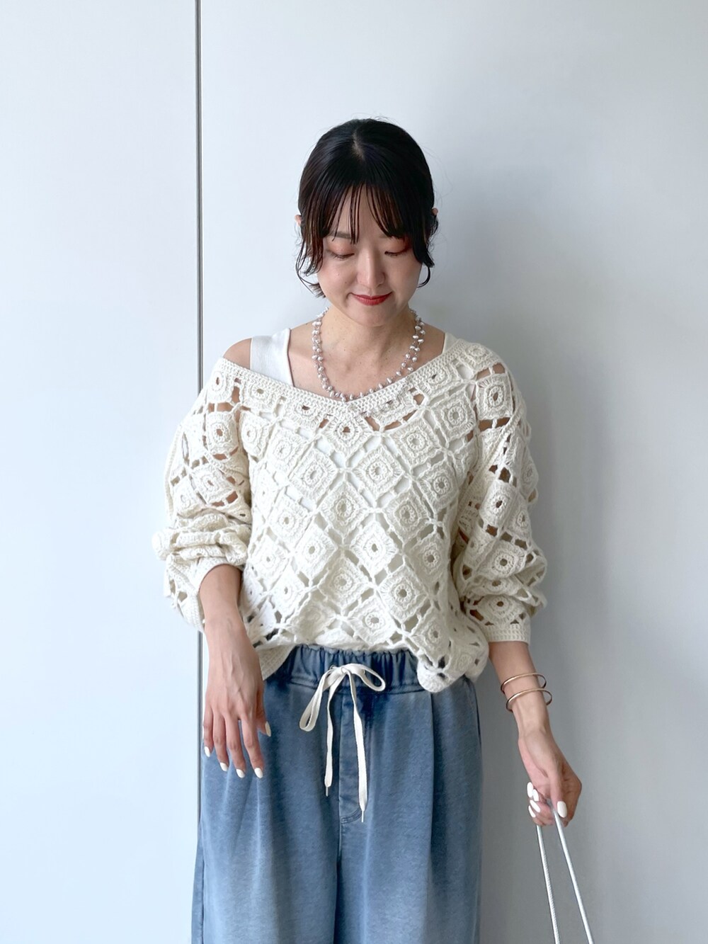 ホワイト系のニット/セーター、ブルー系のその他パンツ、シルバー系のネックレスを着用したレディースの秋コーディネートの3枚目の写真
