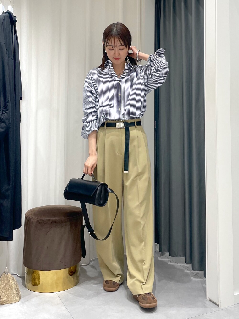 ブルー系のシャツ/ブラウス、ベージュ系のその他パンツ、ブラック系のショルダーバッグを着用したレディースの春コーディネートの2枚目の写真