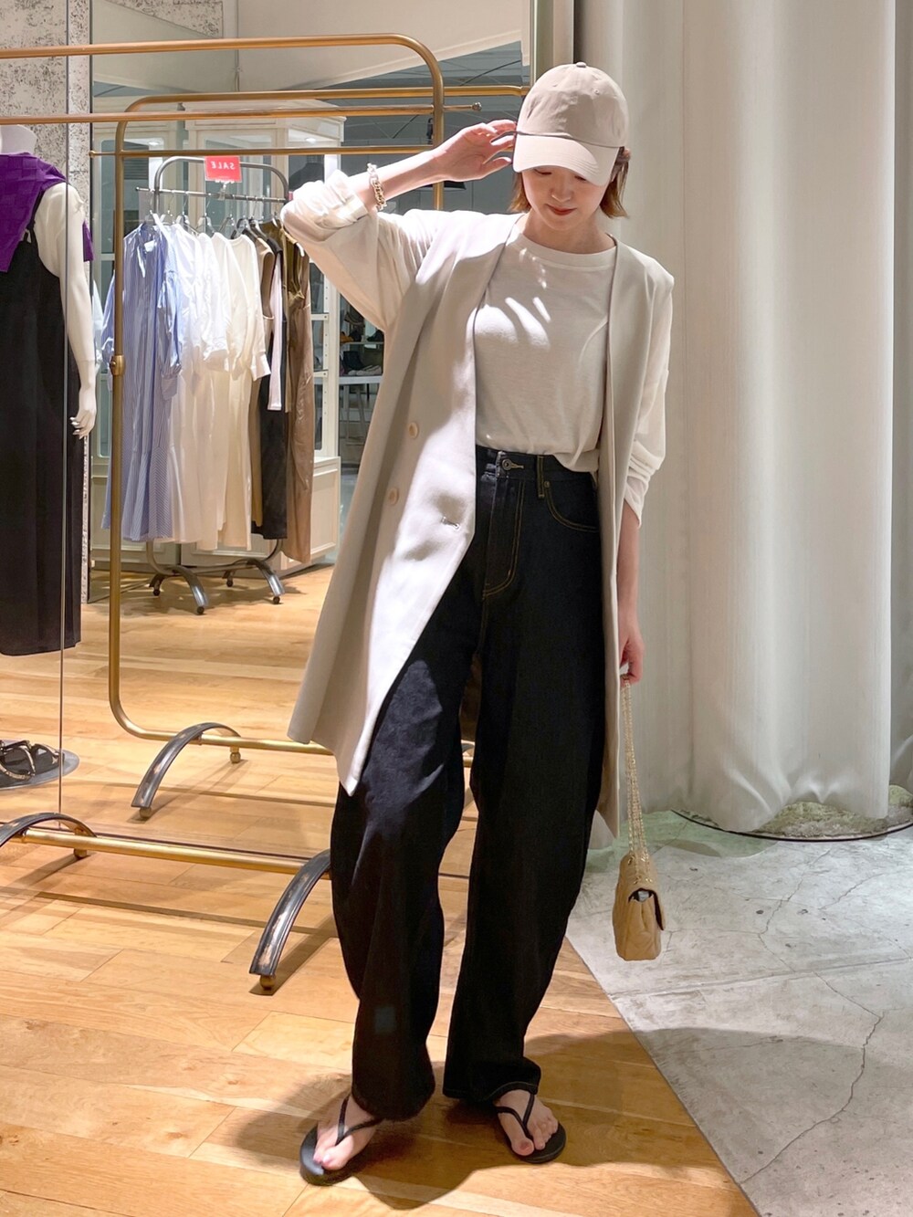 ベージュ系のベスト、ホワイト系のTシャツ/カットソー、グリーン系のトートバッグを着用したレディースの夏コーディネートの2枚目の写真