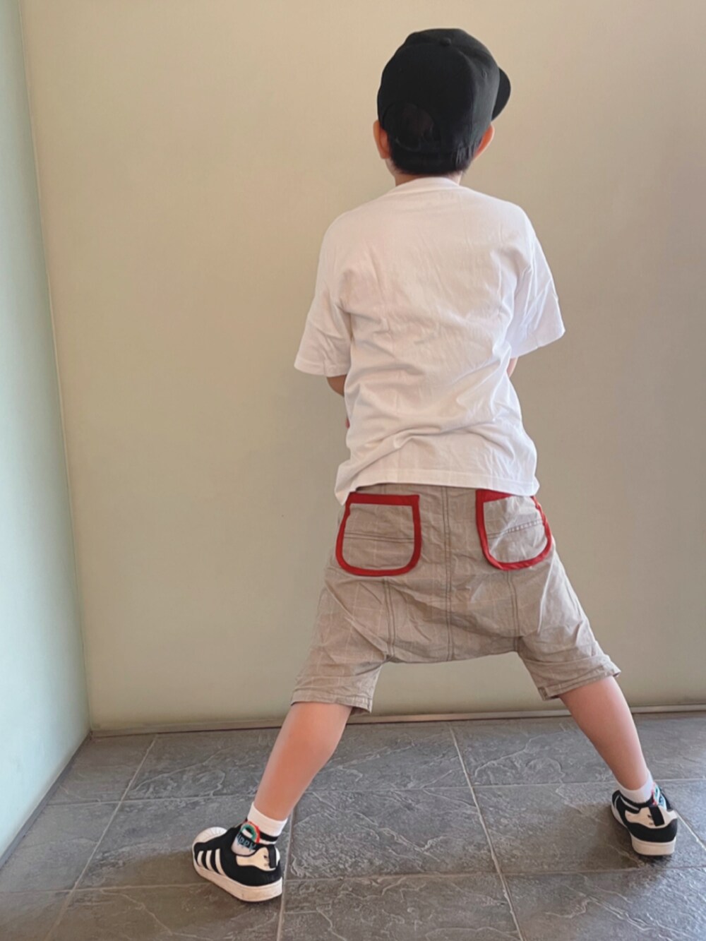 ホワイト系のTシャツ/カットソー、ベージュ系のパンツ、ブラック系のスニーカーを着用したキッズの夏コーディネートの2枚目の写真