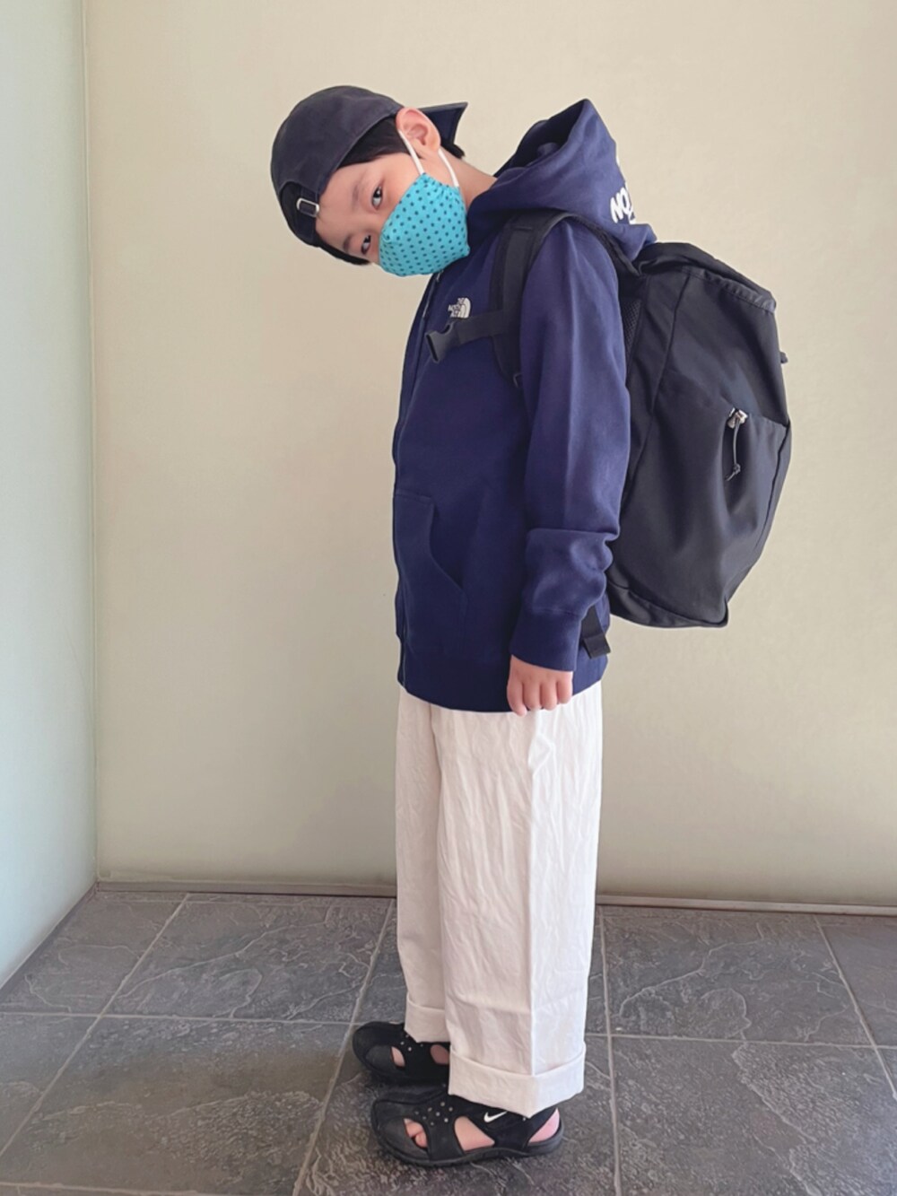 ブルー系のパーカー、ブラック系のバックパック/リュック、ブラック系のサンダルを着用したキッズの冬コーディネートの2枚目の写真
