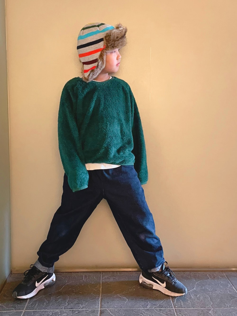 グリーン系のその他トップス、ブルー系のデニムパンツ、ブラック系のスニーカーを着用したキッズの冬コーディネートの2枚目の写真
