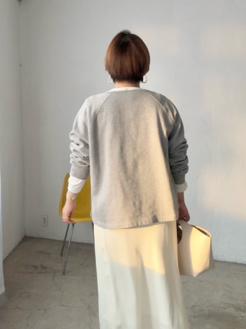 グレー系のスウェット、ホワイト系のTシャツ/カットソー、ホワイト系のスカートを着用したレディースの冬コーディネートの5枚目の写真