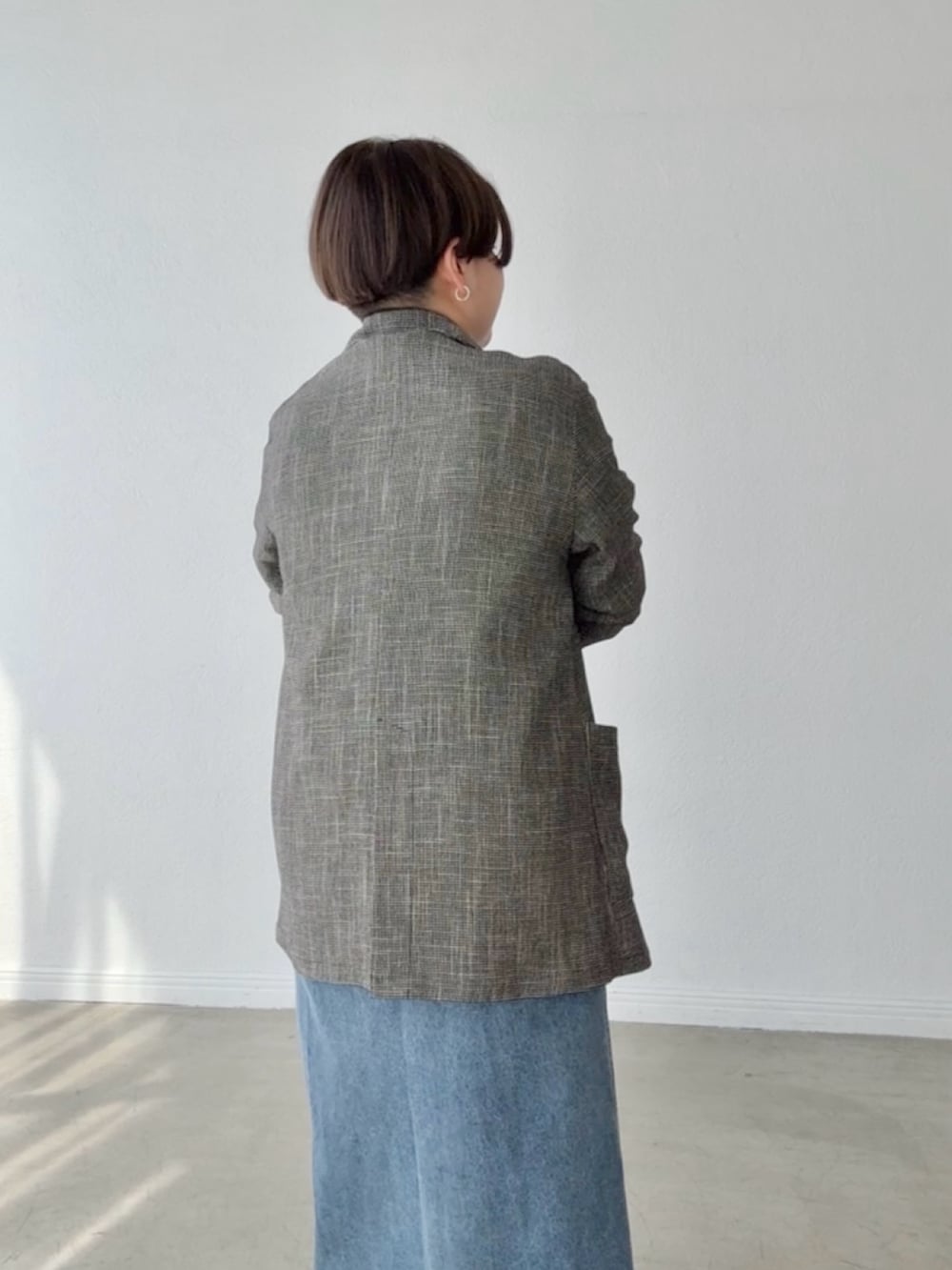 ブルー系のワンピース、ブラック系のテーラードジャケットを着用したレディースの春コーディネートの6枚目の写真