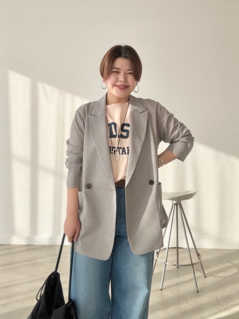 ブルー系のデニムパンツ、ピンク系のTシャツ/カットソー、グレー系のテーラードジャケットを着用したレディースの春コーディネートの3枚目の写真