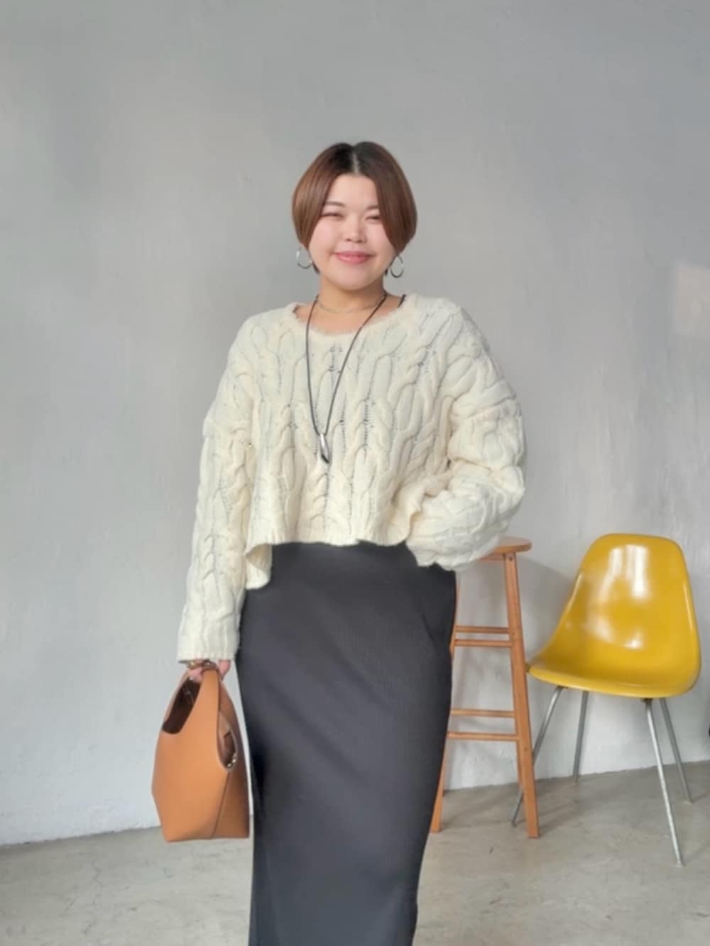 ホワイト系のニット/セーター、ブラック系のワンピースを着用したレディースの冬コーディネートの4枚目の写真