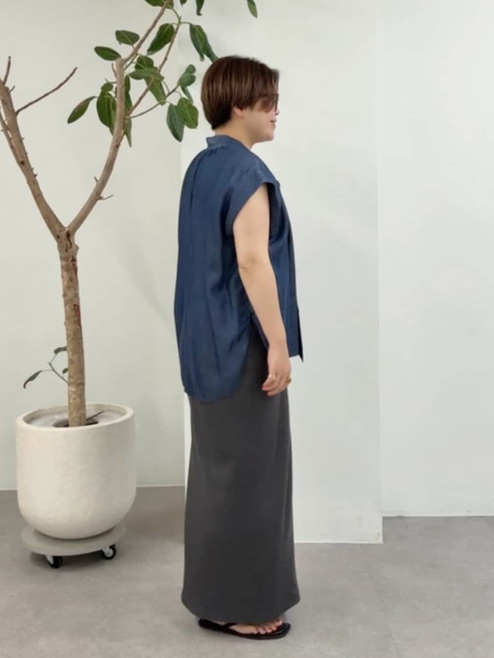 ブルー系のシャツ/ブラウス、グレー系のワンピース、ブラック系のショルダーバッグを着用したレディースの夏コーディネートの2枚目の写真