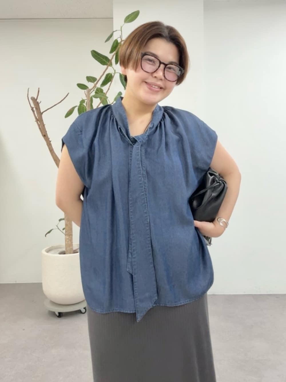 ブルー系のシャツ/ブラウス、グレー系のワンピース、ブラック系のショルダーバッグを着用したレディースの夏コーディネートの4枚目の写真