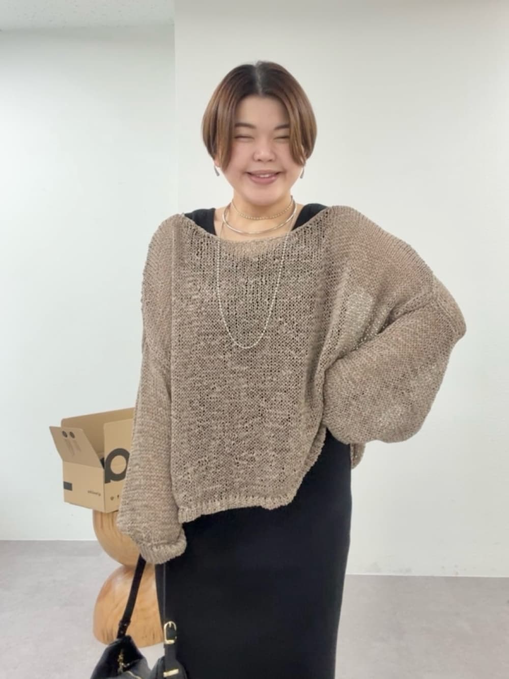 ブラウン系のニット/セーター、ブラック系のワンピースを着用したレディースの冬コーディネートの4枚目の写真