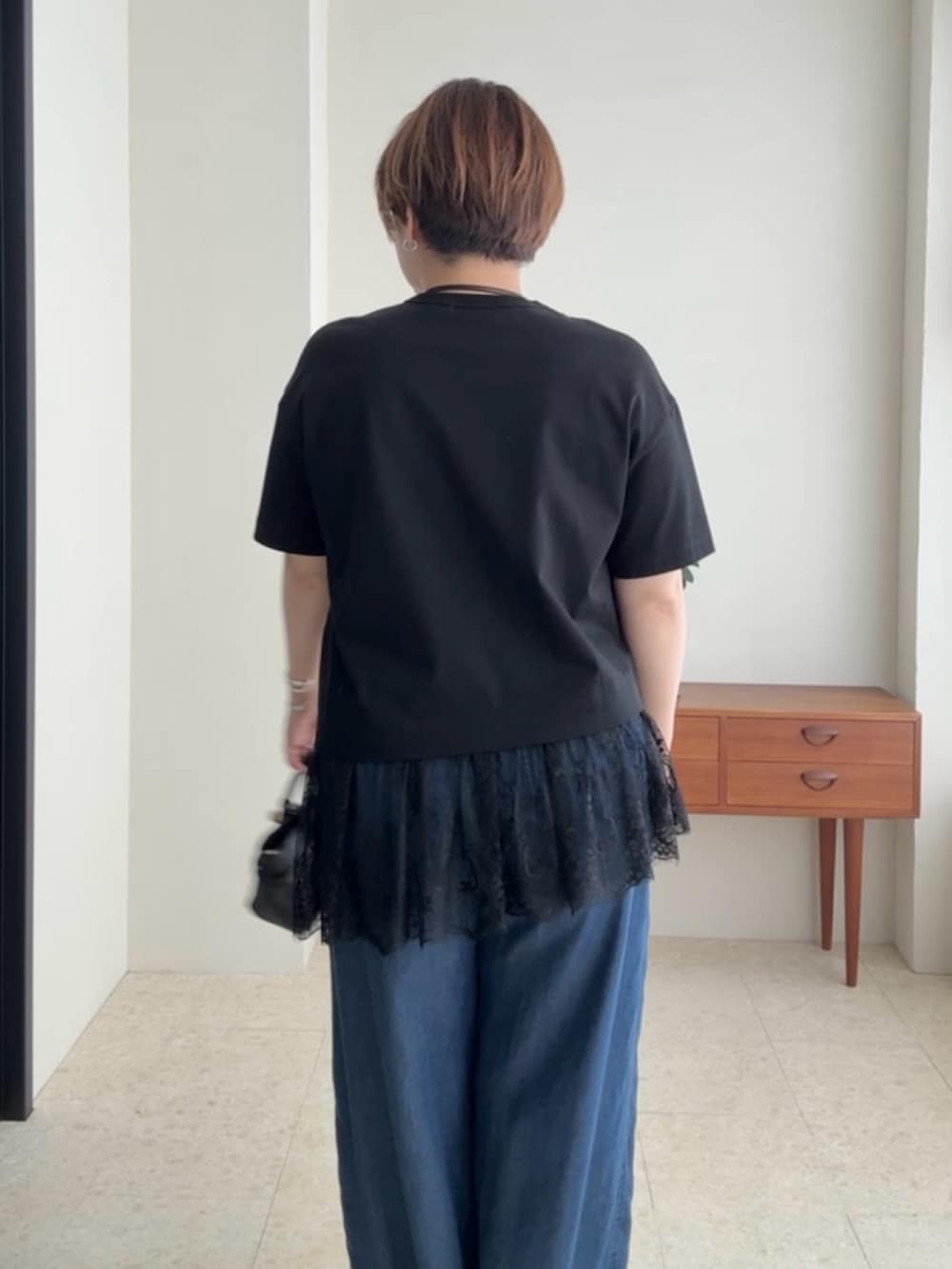 ブラック系のTシャツ/カットソー、ブルー系のデニムパンツを着用したレディースの夏コーディネートの6枚目の写真