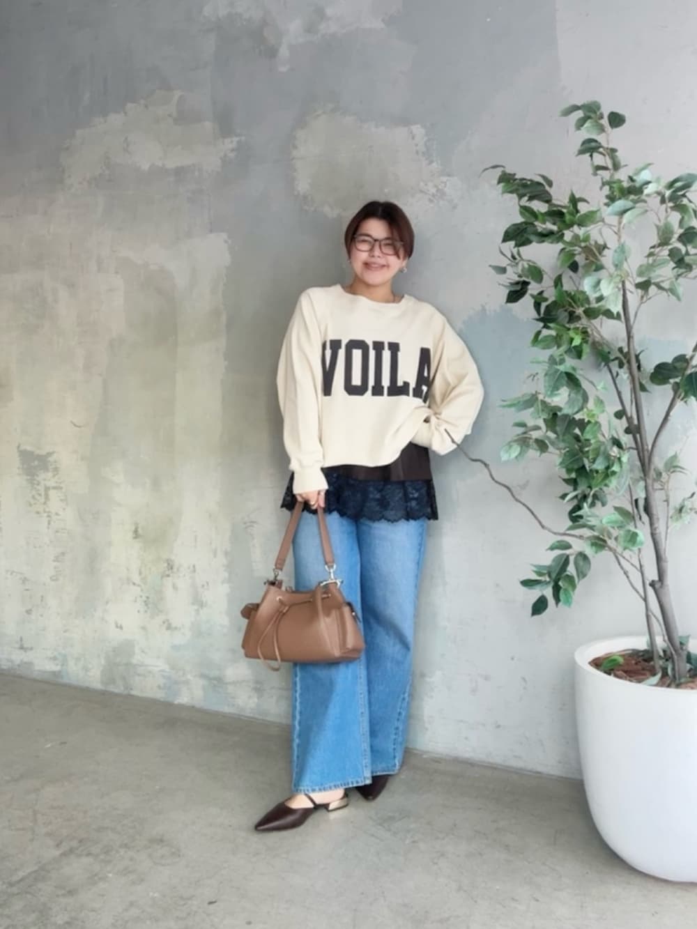 ホワイト系のスウェット、ブラウン系のキャミソール、ブルー系のデニムパンツを着用したレディースの冬コーディネートの2枚目の写真