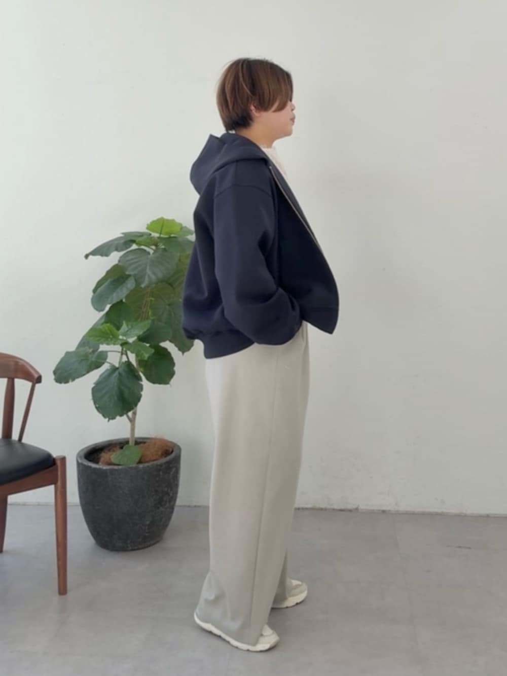 ブルー系のパーカー、ホワイト系のシャツ/ブラウス、ベージュ系のスラックスを着用したレディースの冬コーディネートの2枚目の写真