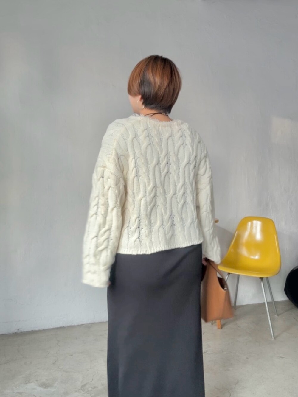 ホワイト系のニット/セーター、ブラック系のワンピースを着用したレディースの冬コーディネートの6枚目の写真