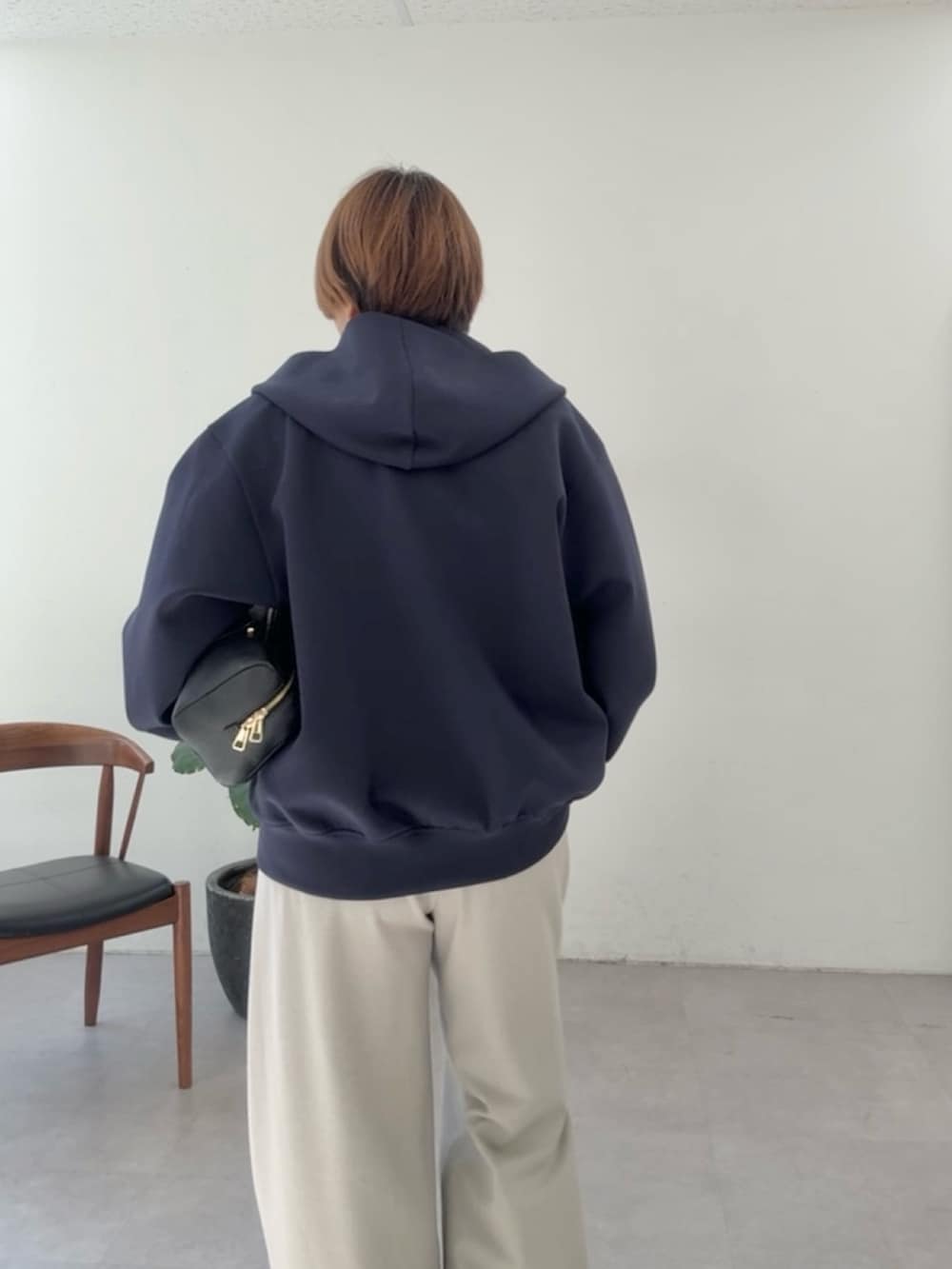 ブルー系のパーカー、ホワイト系のシャツ/ブラウス、ベージュ系のスラックスを着用したレディースの冬コーディネートの5枚目の写真