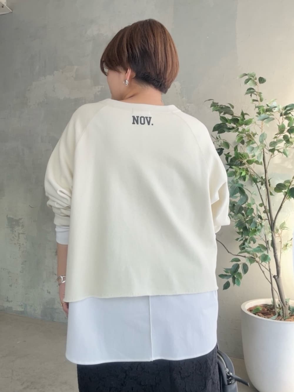 ホワイト系のスウェット、ホワイト系のTシャツ/カットソー、ブラック系のスカートを着用したレディースの冬コーディネートの6枚目の写真