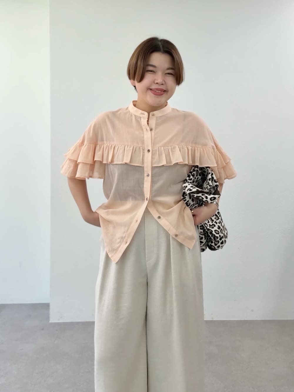 ピンク系のシャツ/ブラウス、ベージュ系のその他パンツ、ベージュ系のトートバッグを着用したレディースの春コーディネートの4枚目の写真