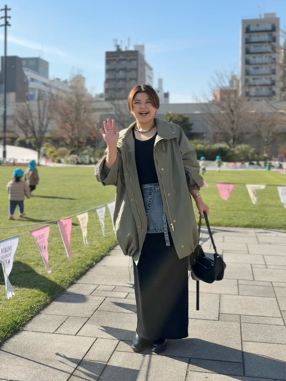 ブルー系のデニムスカート、ブラック系のワンピース、グリーン系のその他アウターを着用したレディースの冬コーディネートの4枚目の写真