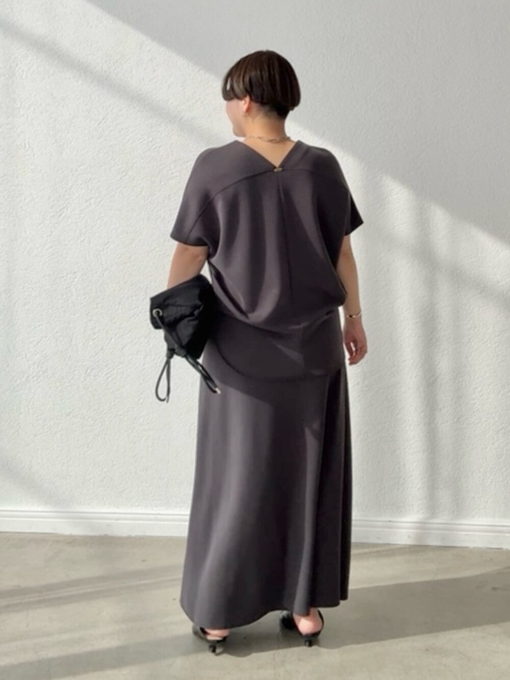 グレー系のTシャツ/カットソー、グレー系のスカートを着用したレディースの春コーディネートの2枚目の写真